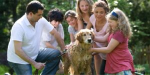 Family giving dog a bath outside, showing shared holistic pet care